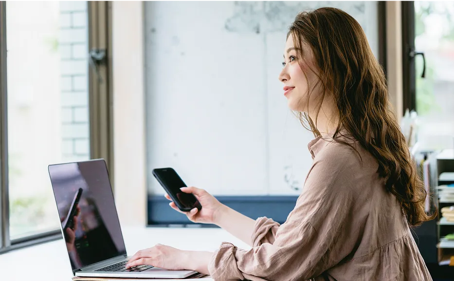 スマホとPCを触る女性