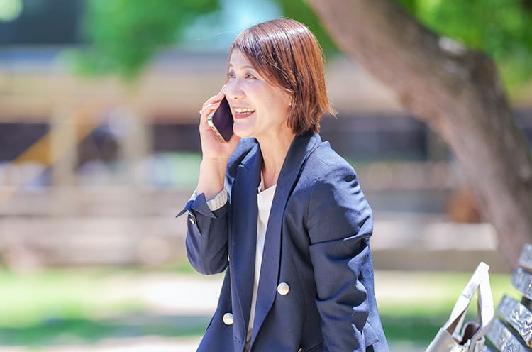 小日向香緒里さんが笑顔で電話をしている写真